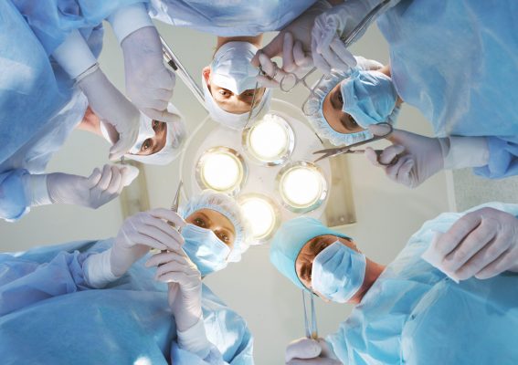 View from below of experienced surgeons with medical tools during operation